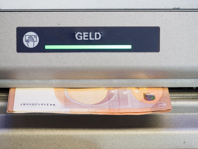 Das Ausgabefach eines Geldautomaten mit einem 50-Euro-Schein.