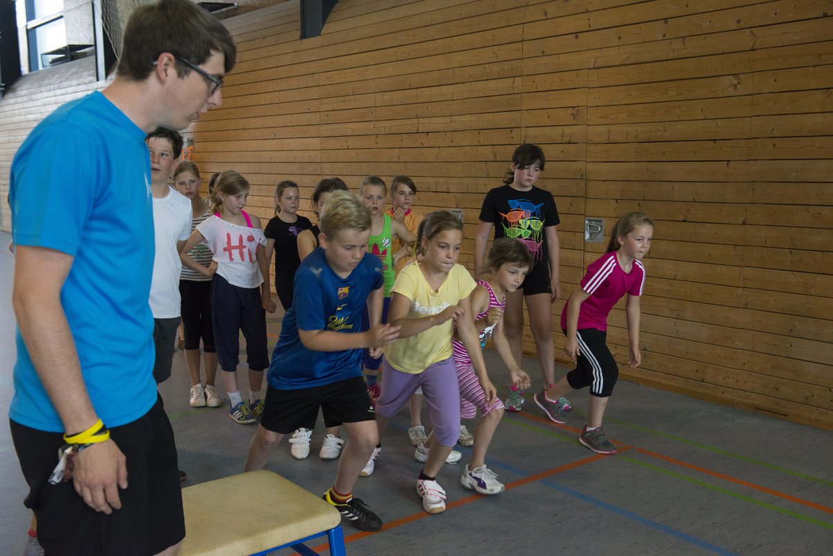 Schülerinnen und Schüler in einer Sporthalle.