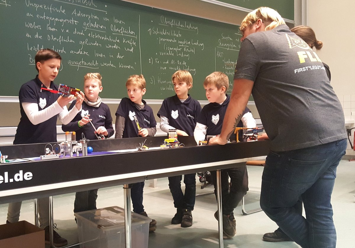 Das BTU-Team RoboFüchse währen des Wettkampfes mit seinem Roboteram am Spieltisch der FIRST® LEGO® League, von links Gregor Agricola, Tim Geike, Justus Mey, Richard Thiele, Leonard Woßlick