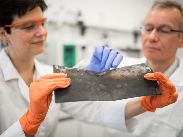 Prof. Jörg Acker und die wissenschaftliche Mitarbeiterin Jana Ducke untersuchen eine Kathodenfolie, die aus einer Lithium-Ionen-Batterie eines Elektroautos nach dessen Demontage entnommen wurde