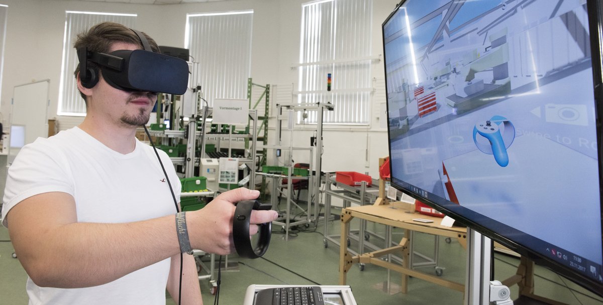 Student im Studiengang Maschinenbau bewegt sich mit VR-Brille in der digitalen Fabrik