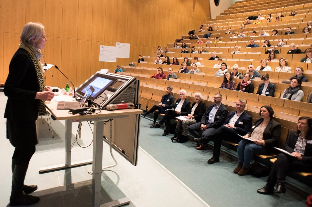 Die BTU-Vizepräsidentin Prof. Dr. Katrin Salchert spricht, am Rednerpult stehend, zu den Teilnehmenden, die im Hörsaal sitzen..