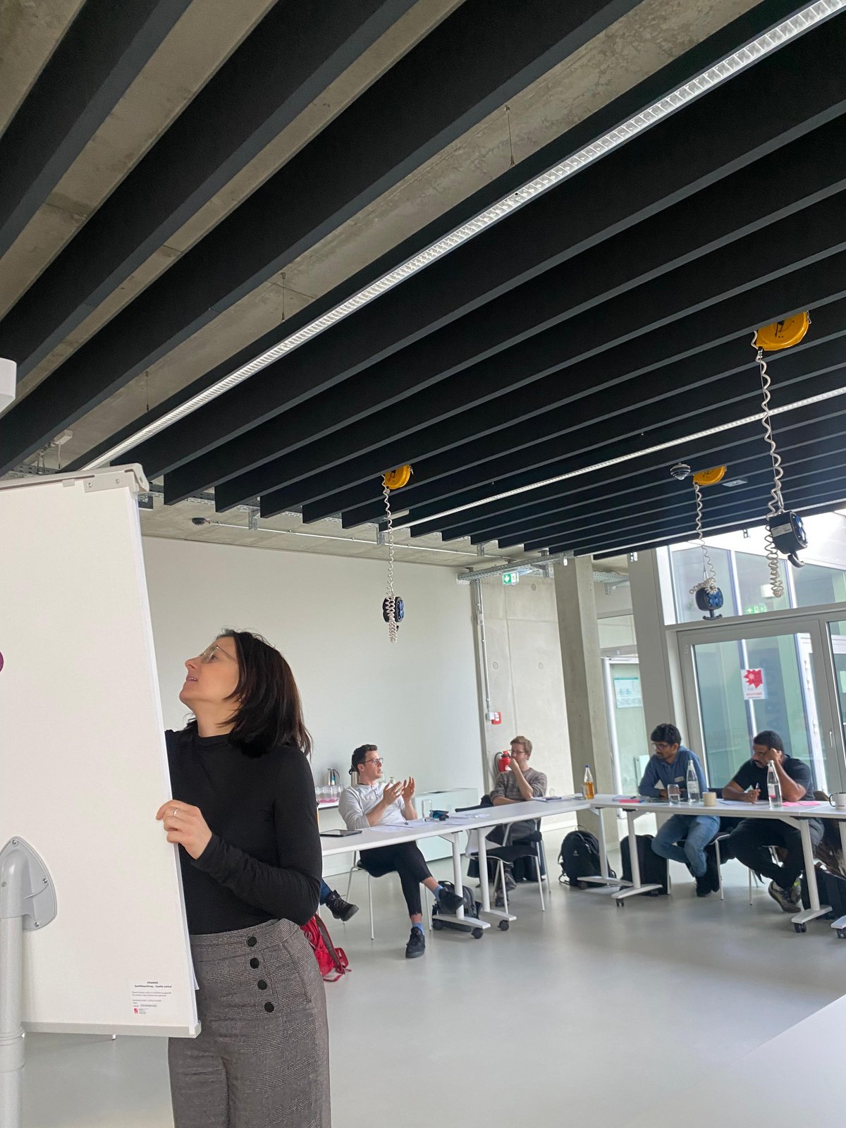 Woman on white board | audience in background