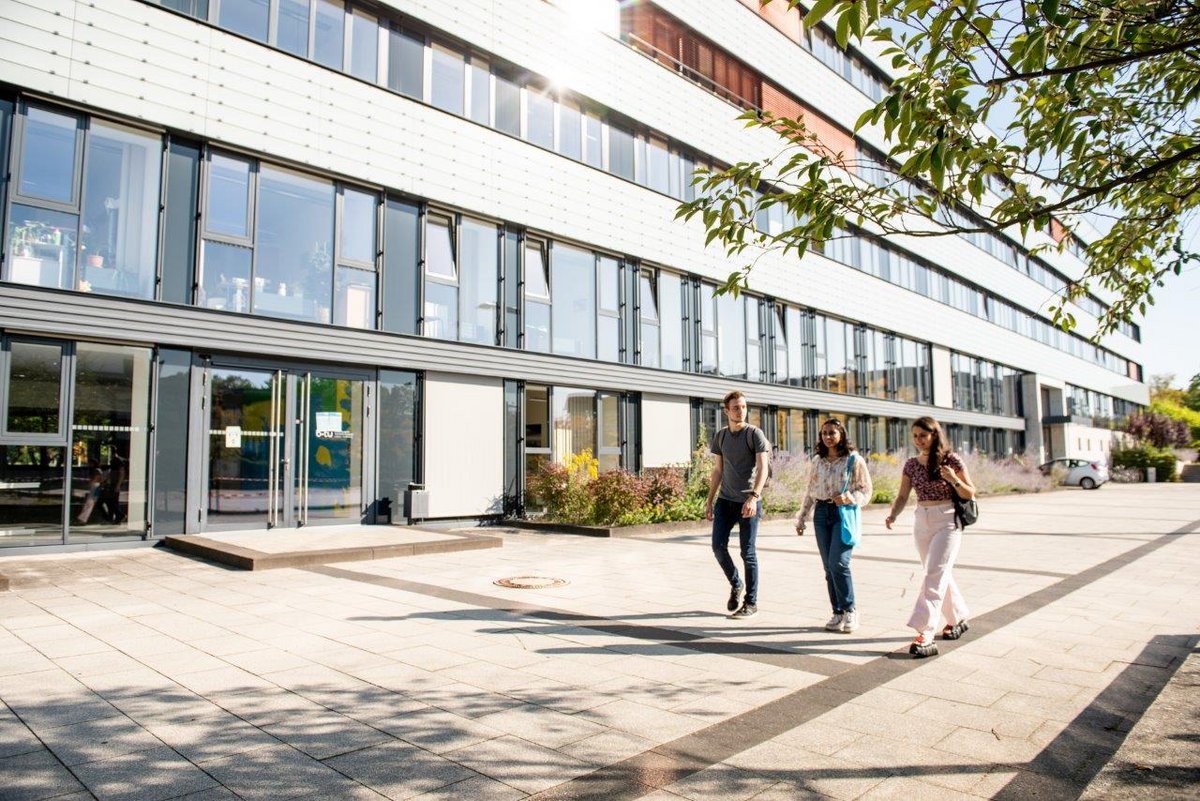 Students walk on the forum, along the main building