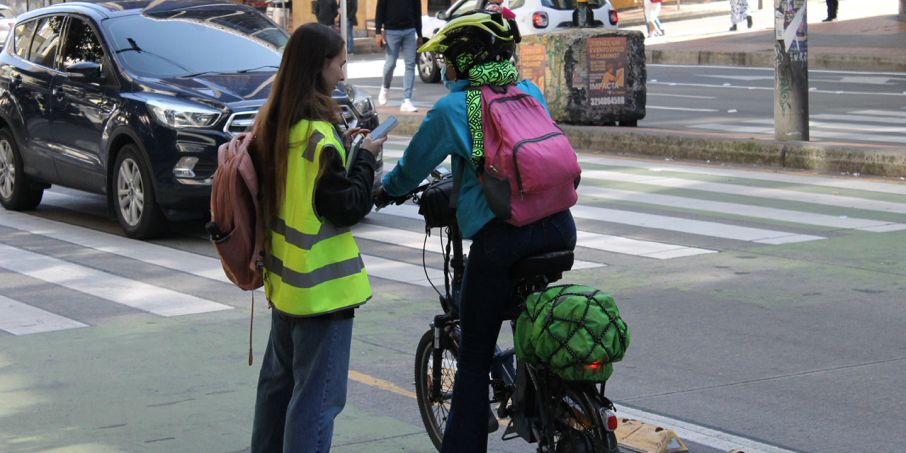 Verkehrsumfrage. Eine Frau auf dem Fahrrad und eine Interviewerin zu Fuß