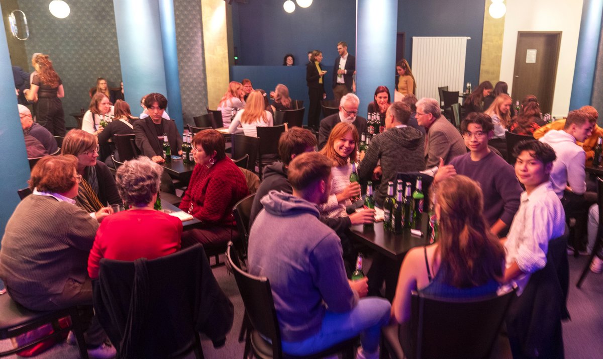 Students, BTU employees and other guests engaged in lively discussions while sitting at tables.