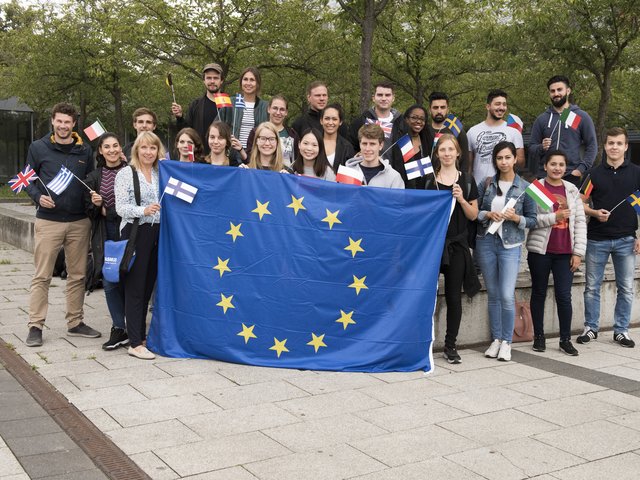 Studierende mit Europa-Fahne vor dem Kirschhain 
