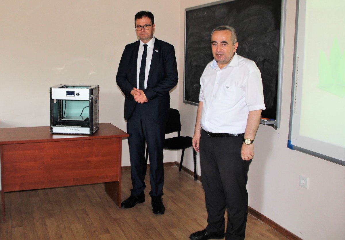 Prof. Sylvio Simon steht mit Dr. Arastun Mamedov, Dekan der Fakultät Maschinenbau der AzTU, neben eienm 3 D-Drucker, den Prof. Simon für das Institut für Umwelttechnik und Recycling Senftenberg e.V. als Gastgeschenk überreicht hat.