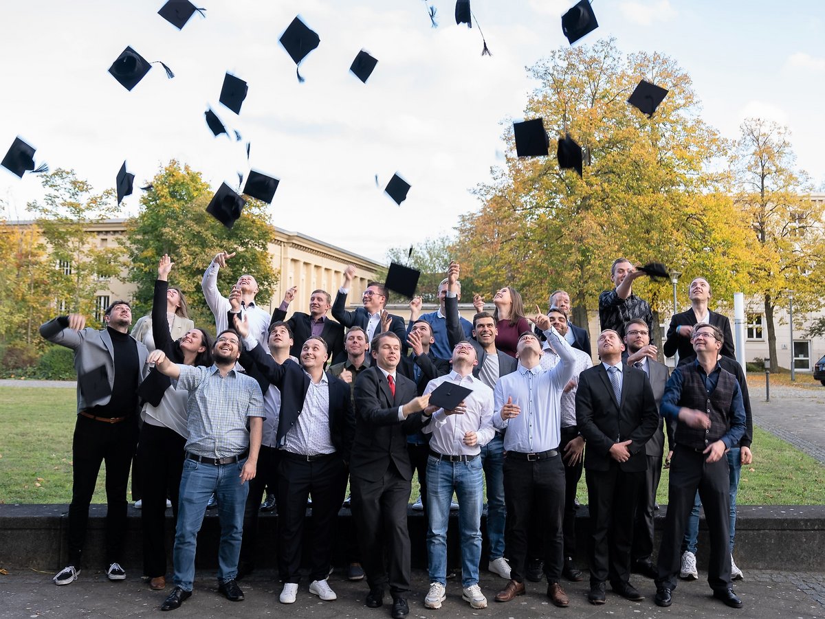 Graduates throw their graduation hats into the air.