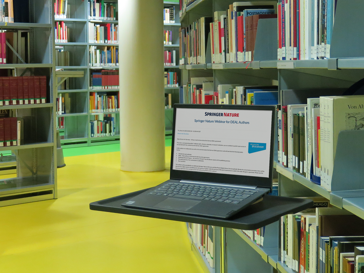 A laptop in front of bookshelves