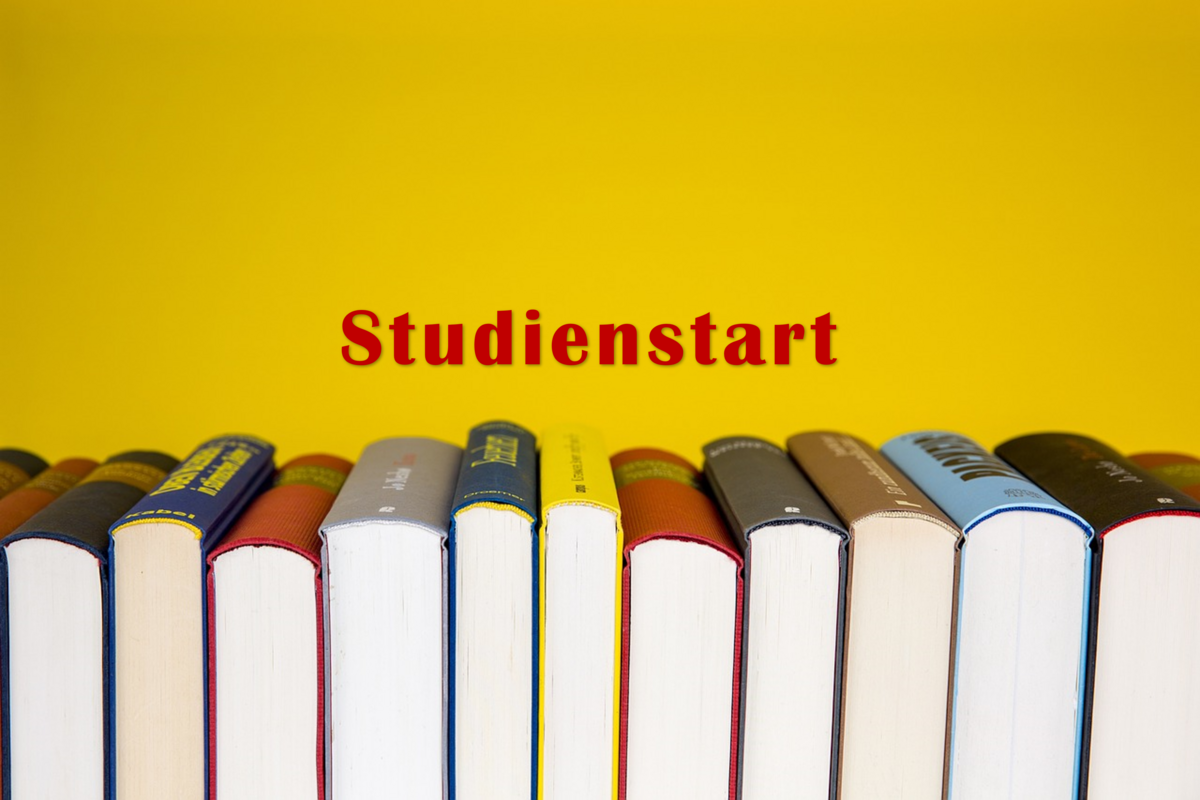 Das Foto zeigt vor einem gelben Hintergund aufgstellte Bücher und den Schriftzug Studienstart.