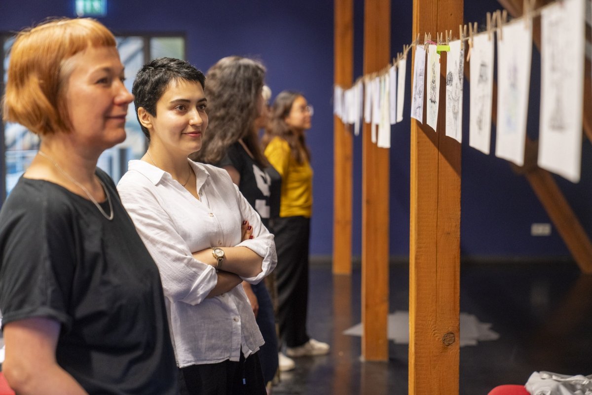 Workshop-Teilnehmende begutachten ihre Zeichnungen, im Vordergrund Ekaterina Orba und Niloofar Soleymani.