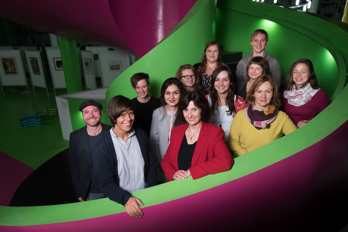 Das Team der Forschungsplattform ist mit insgesamt 12 Mitarbeitern auf der Treppe der Unibibliothek abgebildet