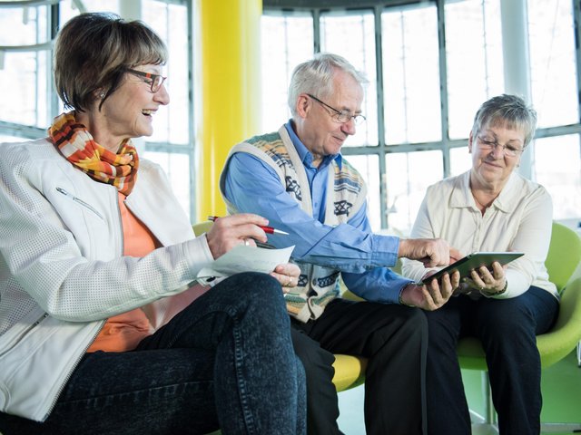 Two seniors and one senior work on a tablet. Photo: BTU, Sebastian Rau Sebastian Rau