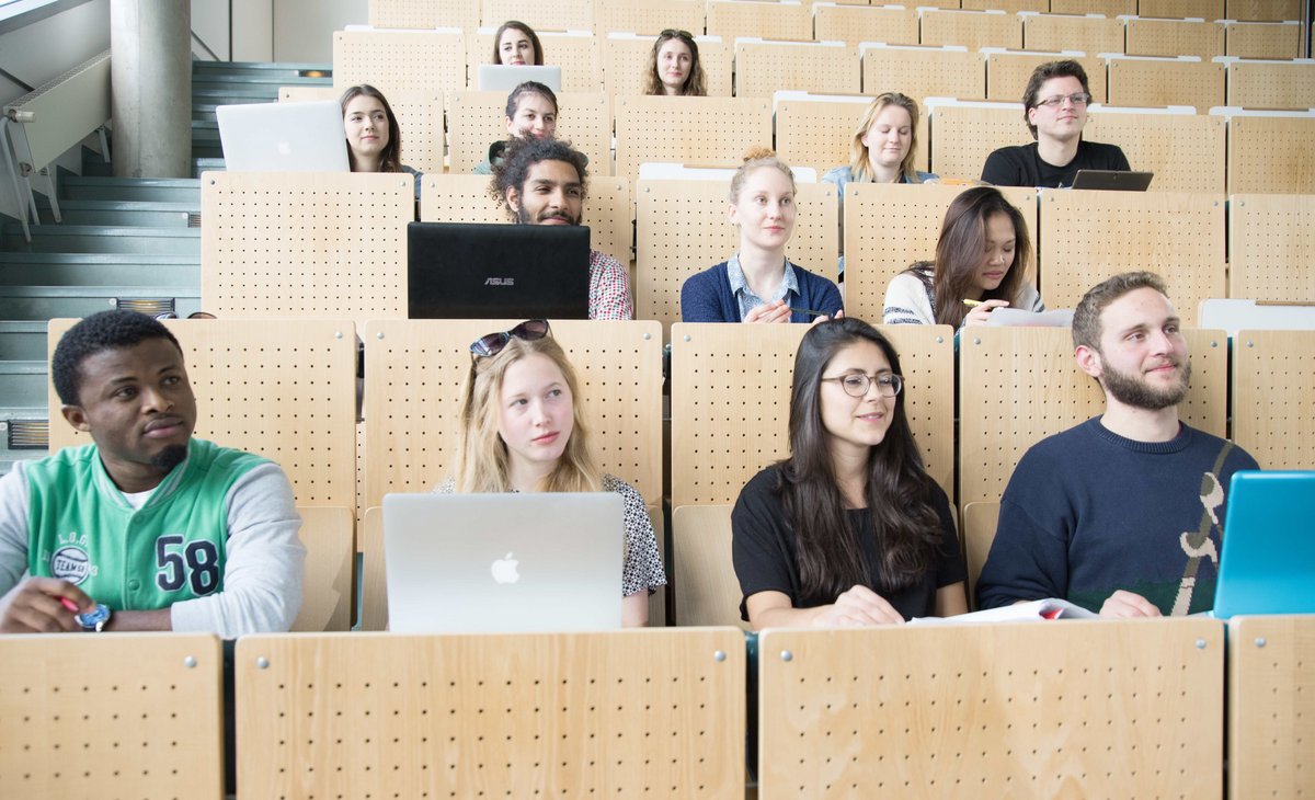 Studierende folgen, im Hörsaal sitzend, einer Vorlesung.