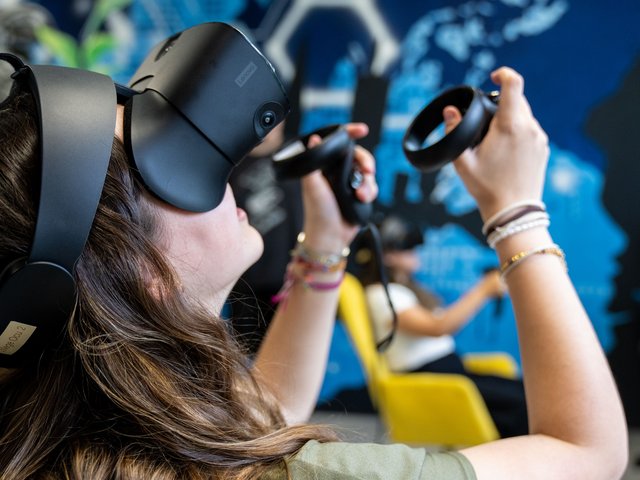 Ein Teilnehmerin mit VR-Brille blickt nach oben.