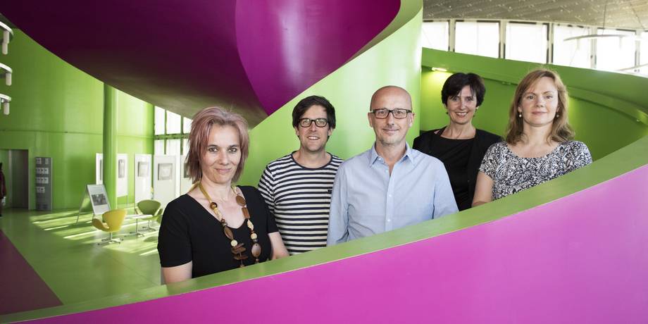 Fünf neu berufene Professorinnen und Professoren stehen auf der Spindeltreppe in den BTU-Farben in der Universitätsbibliothek