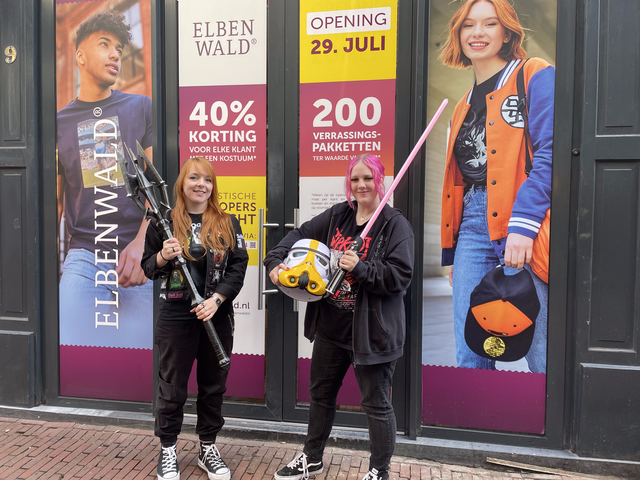 Zwei Mitarbeiterinnen posieren vorm Eingang des Ladens Elbenwald