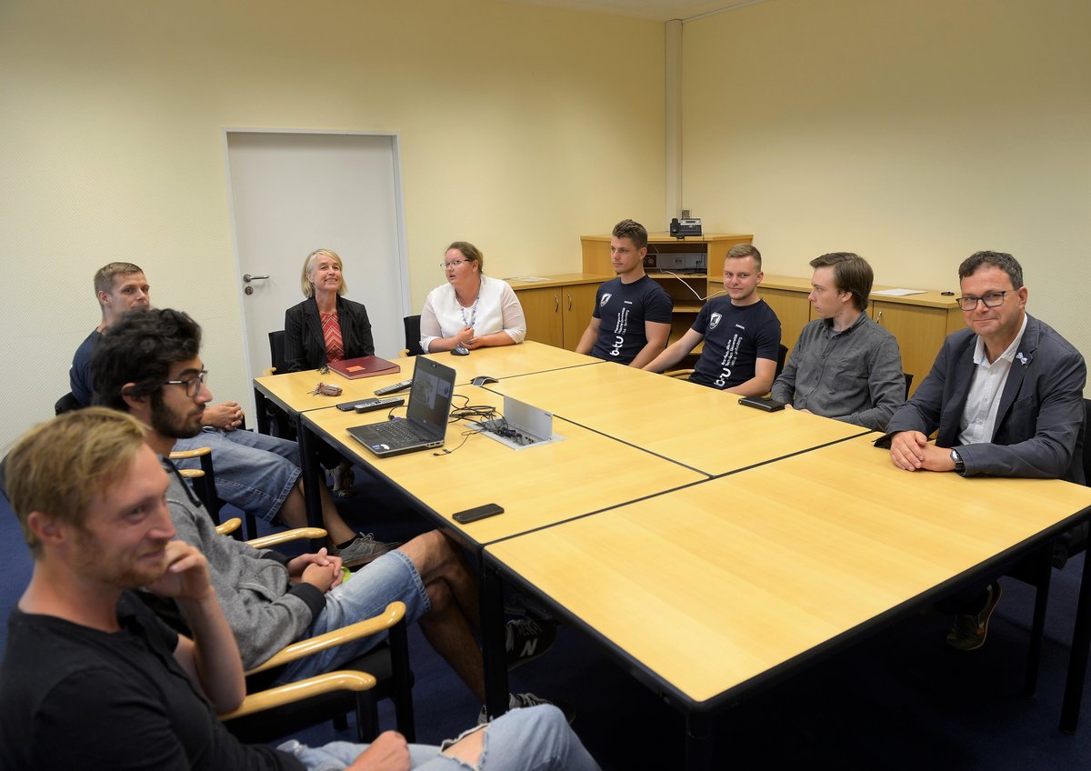 Studierende vom Team Lauistz Dynamics diskutieren, um einne großen Tisch sitzend, mit der amtierendne Präsidentin der BTU Cottbus-Senftenberg Prof. Dr. Christiane Hipp 