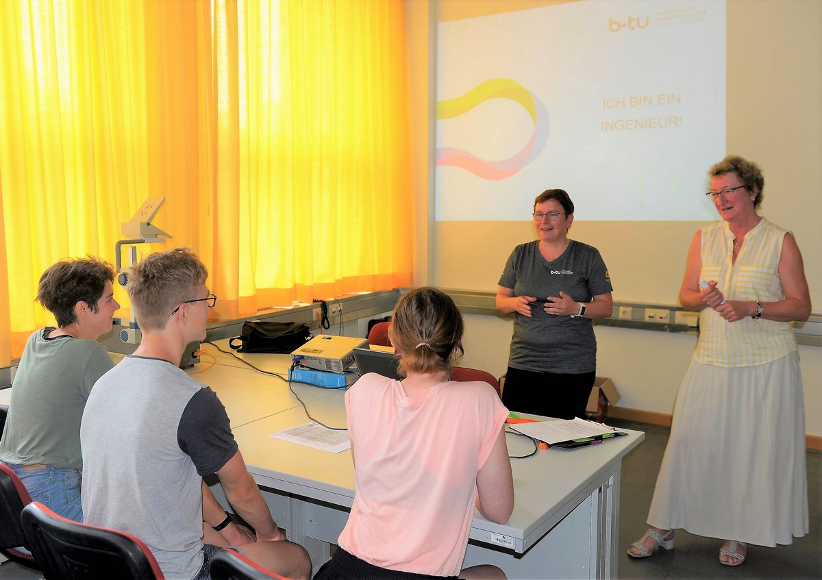 Die Prodekanin der Fakultät 3 Prof. Dr.-Ing. Kathrin Lehmann und Studienberaterein Heike Postelt stehern vor den am Tisch sitzenden Schülern und begrüßen diese.