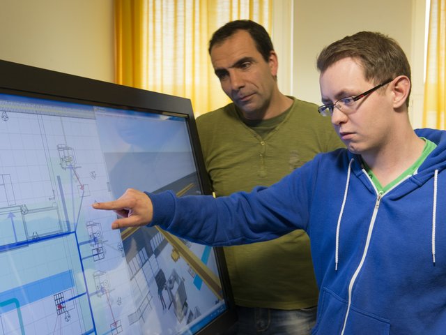 Besprechung am Planungstool der Fabrikplanung, die einen Schwerpunkt im Tagungsprogramm bildet