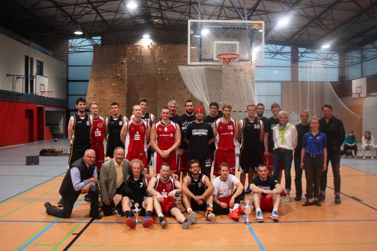 Die Basketballmannschaften der BTU und der Uni Landau in einem Gruppenbild in einer Turnhalle.