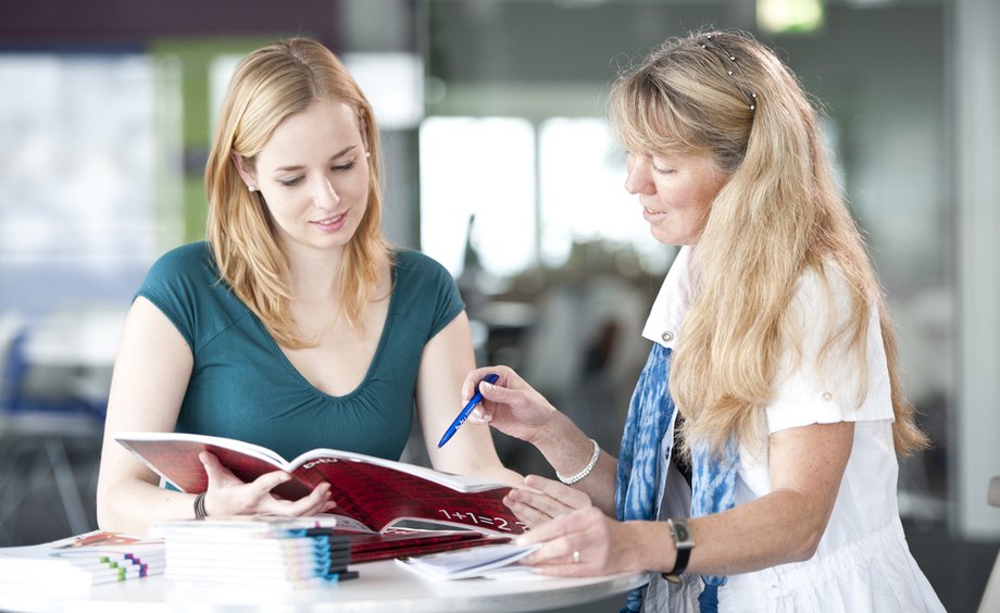 Eine Studieninteressierte wird beraten, die Studienberaterin bespricht mit der Studieninteressierten anhand einer Broschüre Details zum gewünschten Studiengang.