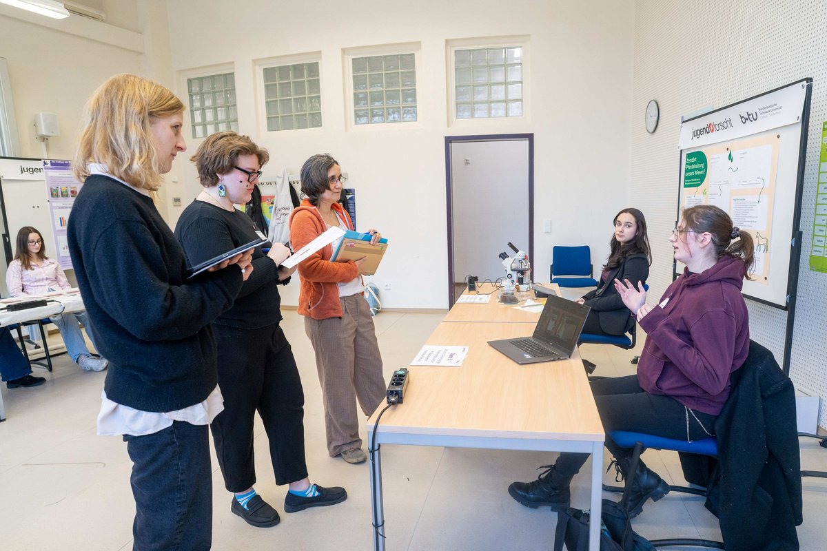 Juryvertreter im Bereich Biologie im Gespräch mit Teilnehmenden.