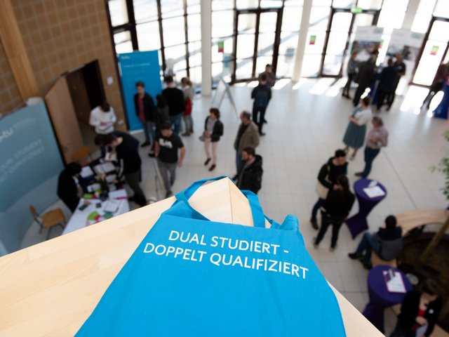 Stueieninteressierte informieren sich an Ständen im Foyer des Konrad-Zuse-Medienzentrums über duale Studienmöglichkeiten.
