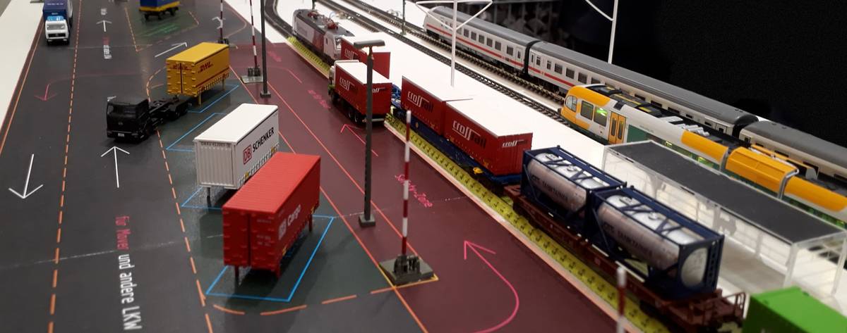 In einem Modell werden Güter zwischen LKW und Zug verladen.