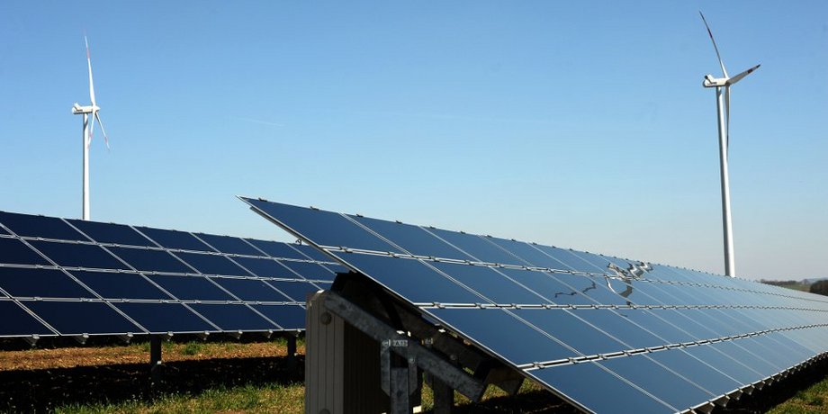 Solarpanels und dahinterstehende Windräder