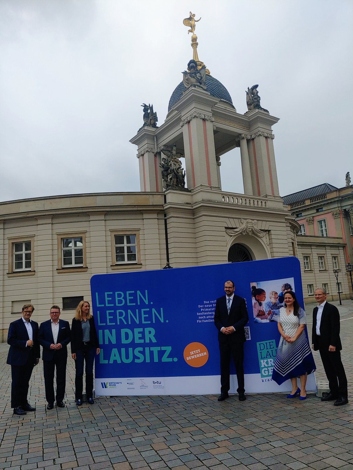 Gruppe vor Großplakat Leben. Lernen. in der Lausitz.