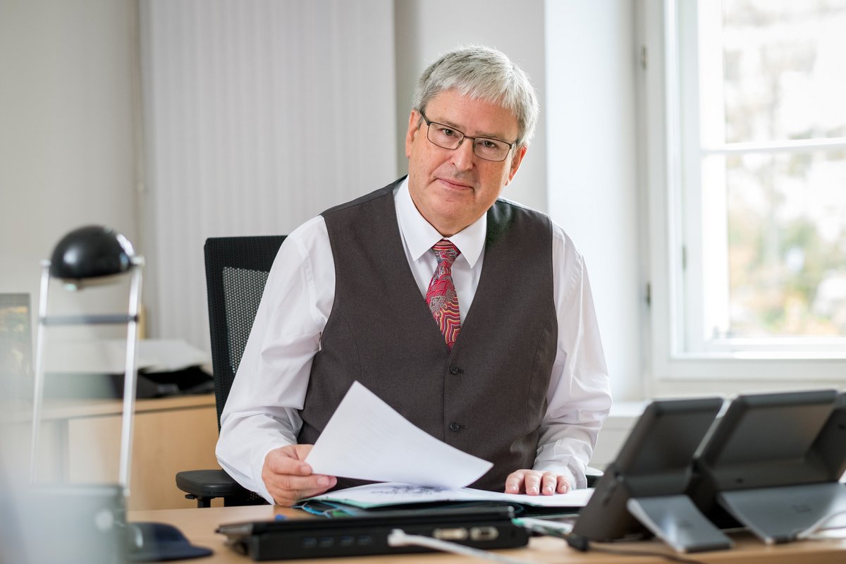 Prof. Steinbach sitzt an seinem Schreibtisch im Ministerium