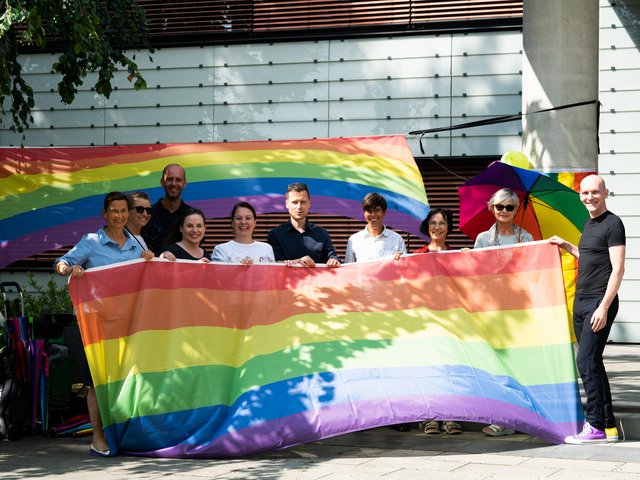 BTU-Angehörige und Mitglieder von CSD Cottbus e.V. halten gemeinsam die Regenbogenflagge