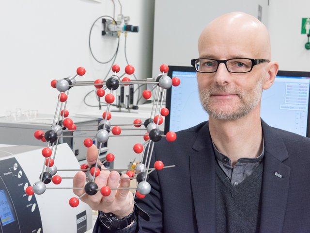 Prof. Peer Schmidt mit einem Modell einer Kristallstrukturr
