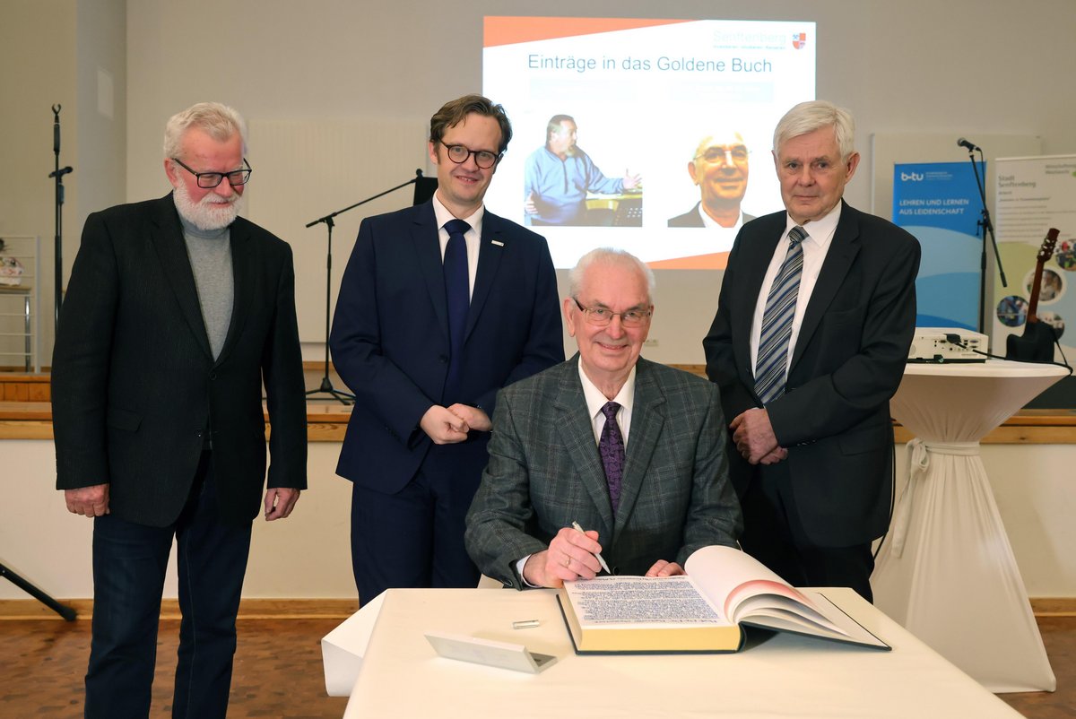 Der Gründungsrektor der Fachhochschule Lausitz Prof. Dr. Dr. Roland Sessner beim Eintrag in das Goldene Buch der Stadt Senftenberg, dahinter (von links) der Vorsitzende der Senftenberger Stadtverordnetenversammlung Peter Rössiger, Bürgermeister Andreas Pfeiffer, Prof. Dr.-Ing. Peter Biegel. 