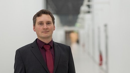 Rene Wickmann befindet sich im Foyer des Gebäudes 3