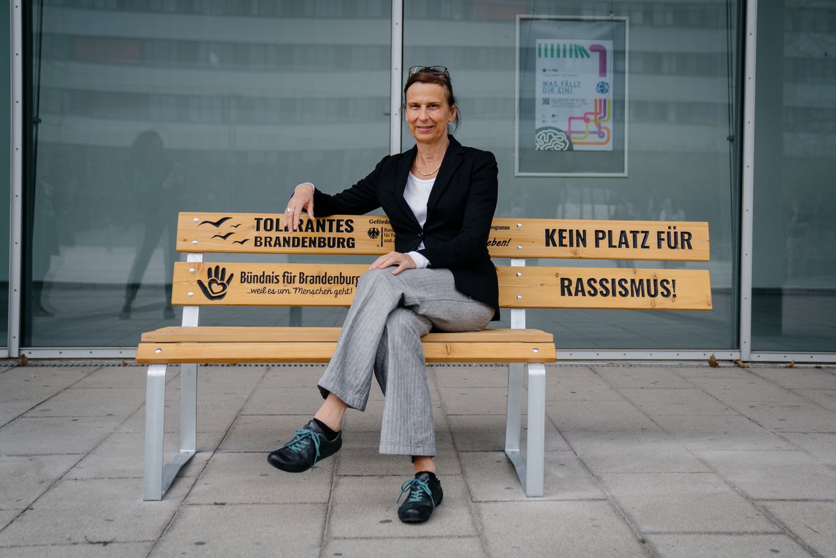 Die Präsidentin sitzt auf der Bank vor dem ZHG