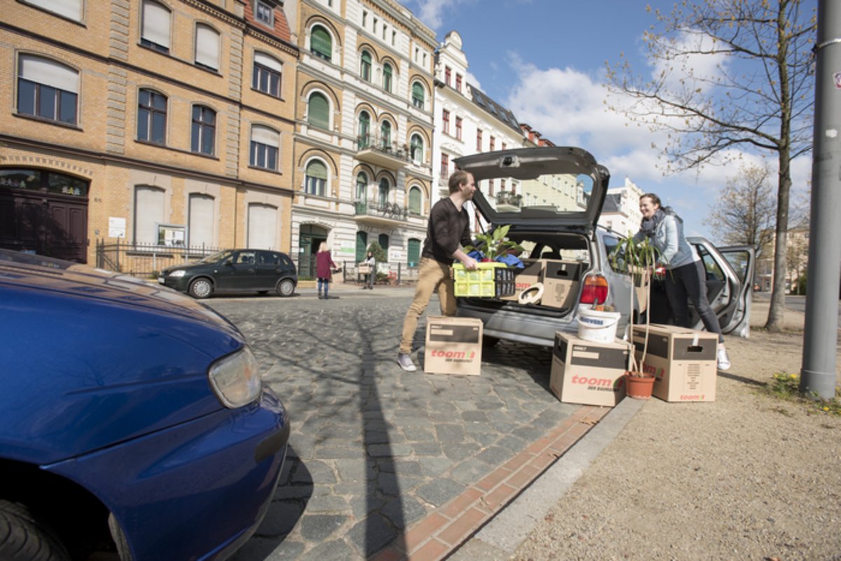Das Foto zeigt einen Umzugswagen und Umzugshelfende.