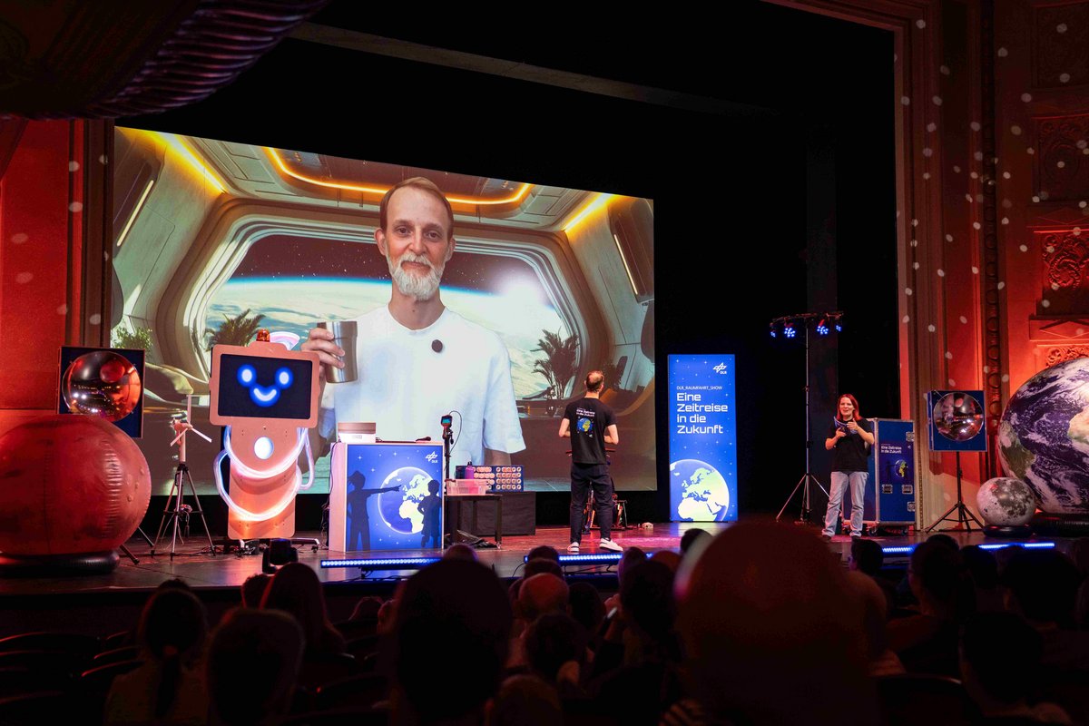 Blick auf die Bühne im Staatstheater, Mann  mit Getränk in einem Raumschiff.