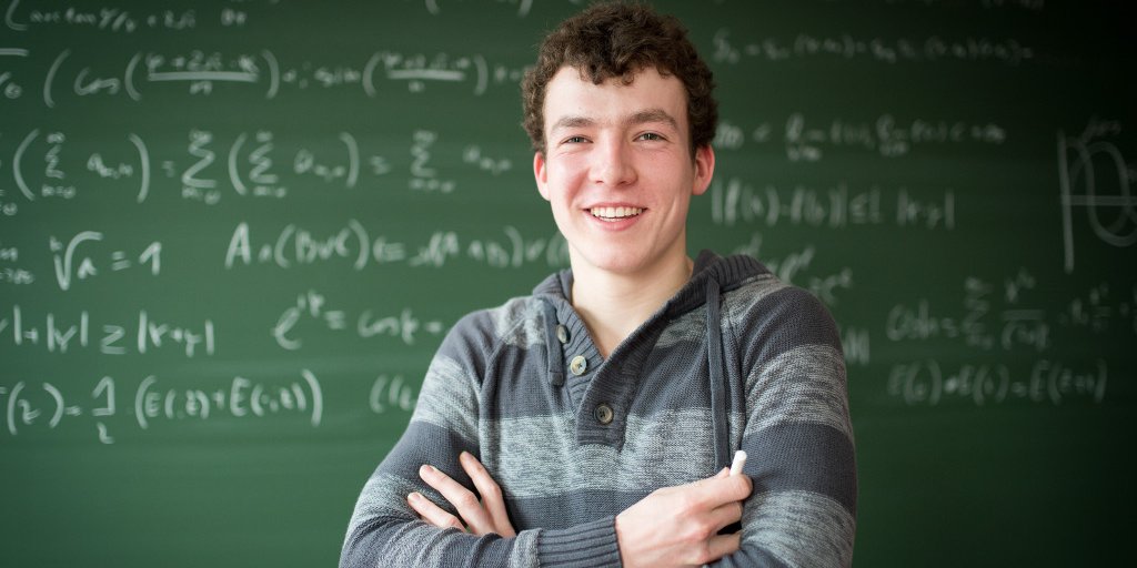 Student in Bachelor Mathematics before mathematical formulas on a blackboard