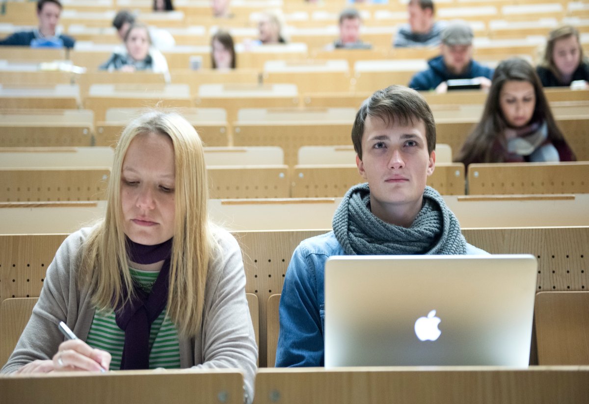 Zwei Studierende einer anderen deutschen Hochschule sitzen im Hörsaal und besuchen eine Vorlesung der BTU.