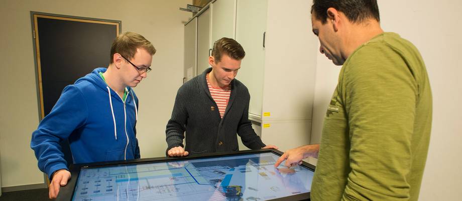 Lehrender und Studierende am Planungstisch