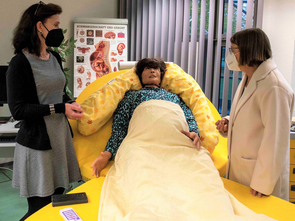 Die Studiengangsleiterin der Hebammenwissenschaft Prof. Franziska Rosenlöcher mit Sozialministerin Ursiula Nonnemacher an einer Gebärpuppe (Geburtssimulator). (Foto: BTU, Ralf Schuster)