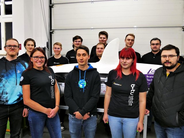 The current Lausitz Dynamics team, standing in front of and behind their vehicle.