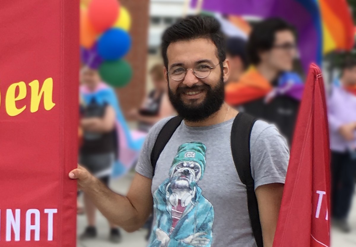 Himmat Aljasem beim CSD 2018 in Cottbus, ein Banner und eine Fahne haltend. Foto: Stefan Fiedler