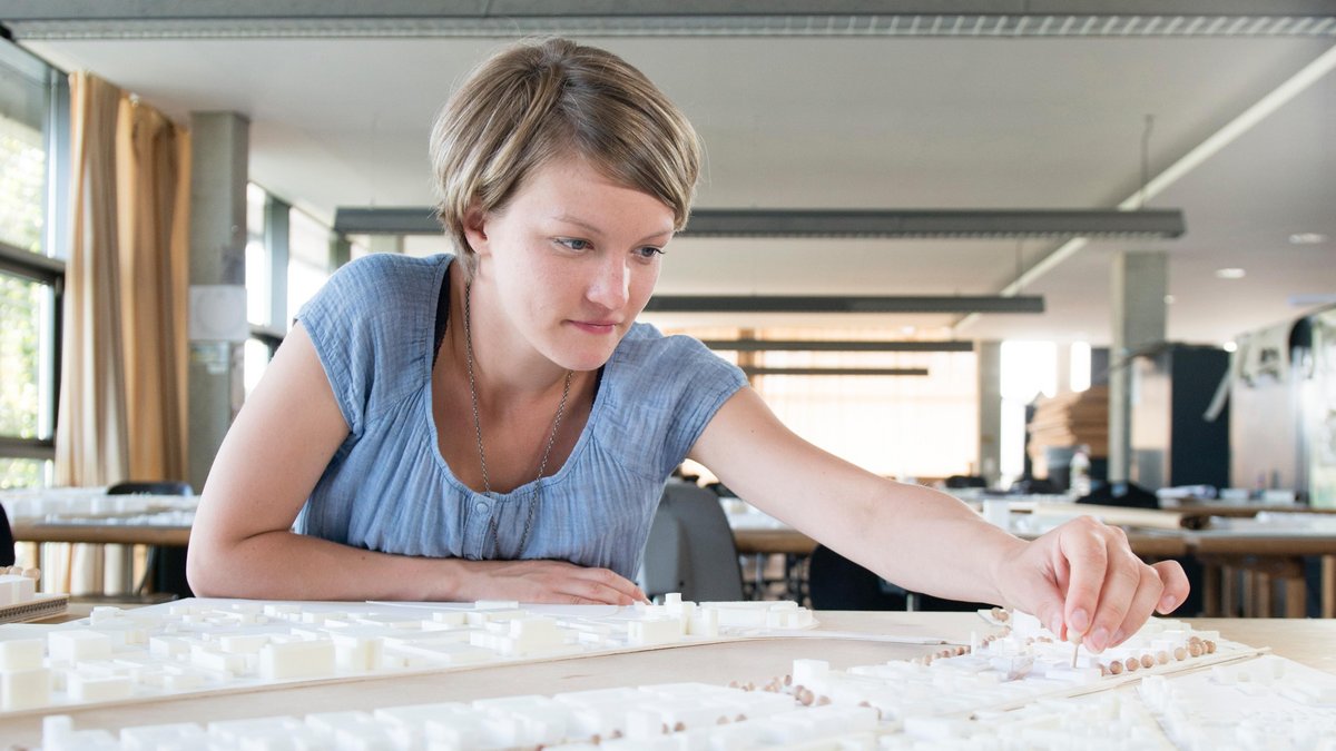 Eine Studentin betrachtet ein Architekturmodell