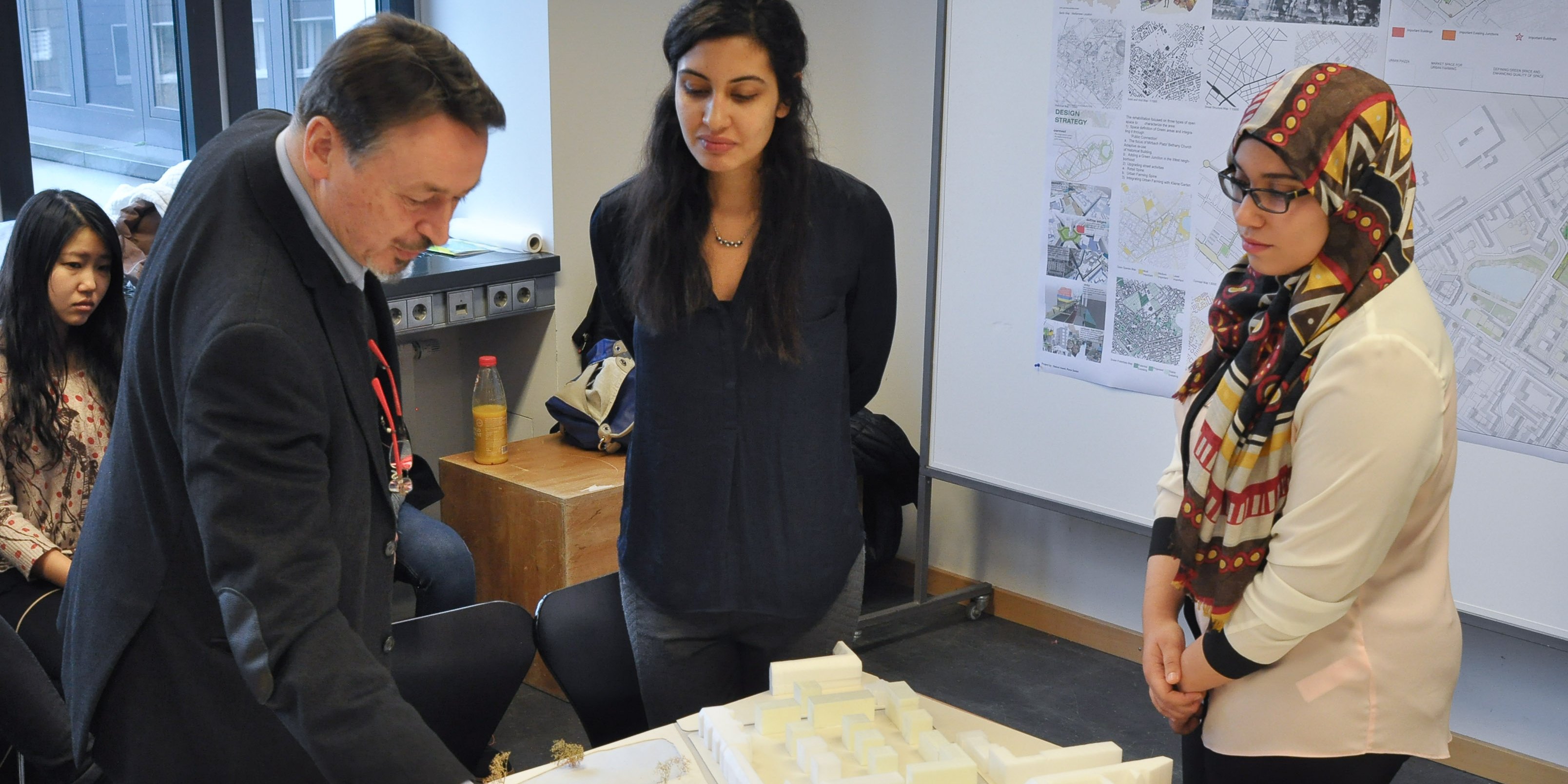 Studentinnen des Master-Studiengangs Urban Design besprechen mit ihrem Professor ein Modell