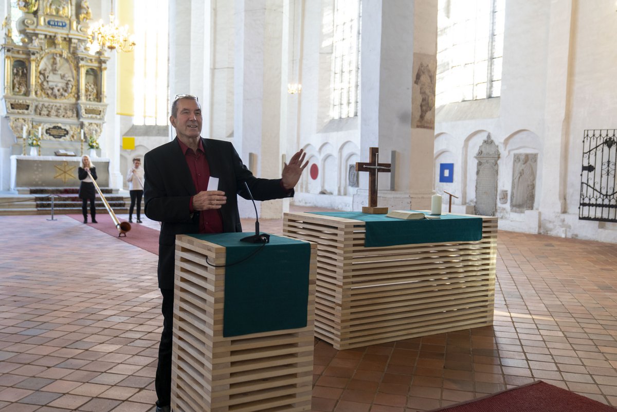 Der Künstler an den von ihm gestalteten Holzaltars