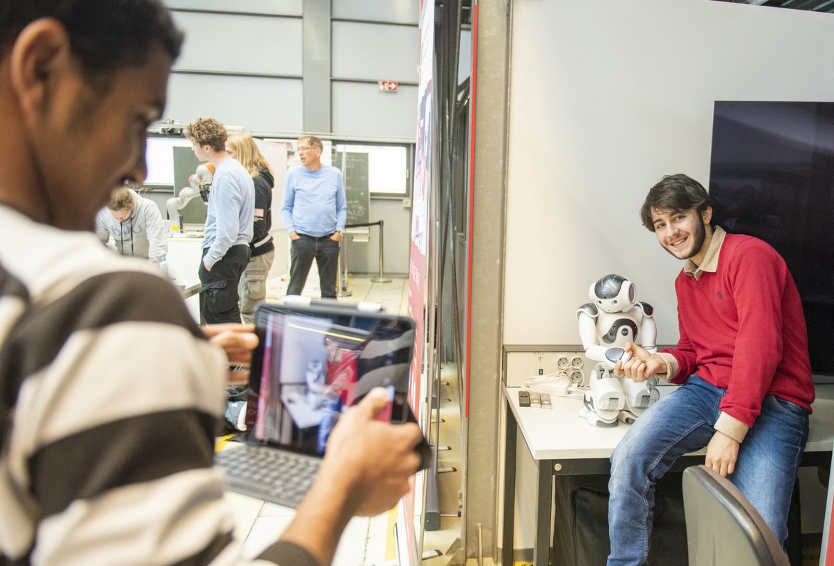 Young people with a small robot. Photo: BTU, Ralf Schuster